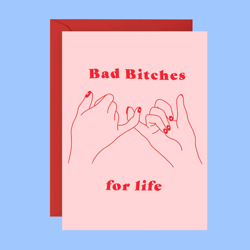 A pink greeting card with red text reading 'Bad Bitches for life' and a simple red line drawing of two hands, shown with a red envelope against a light blue background.
