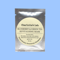 Charlotte's Lab Blueberry & Green Tea Revitalising Mask in a silver foil pouch with a cream-colored circular label, set against a solid light blue background.
