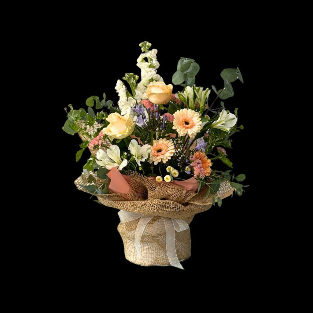 large pastels flower arrangement in a hessian wrapped hat box with white bow