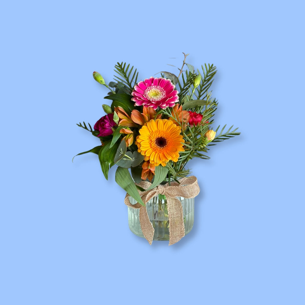 Hand-tied bright seasonal posy in a vase