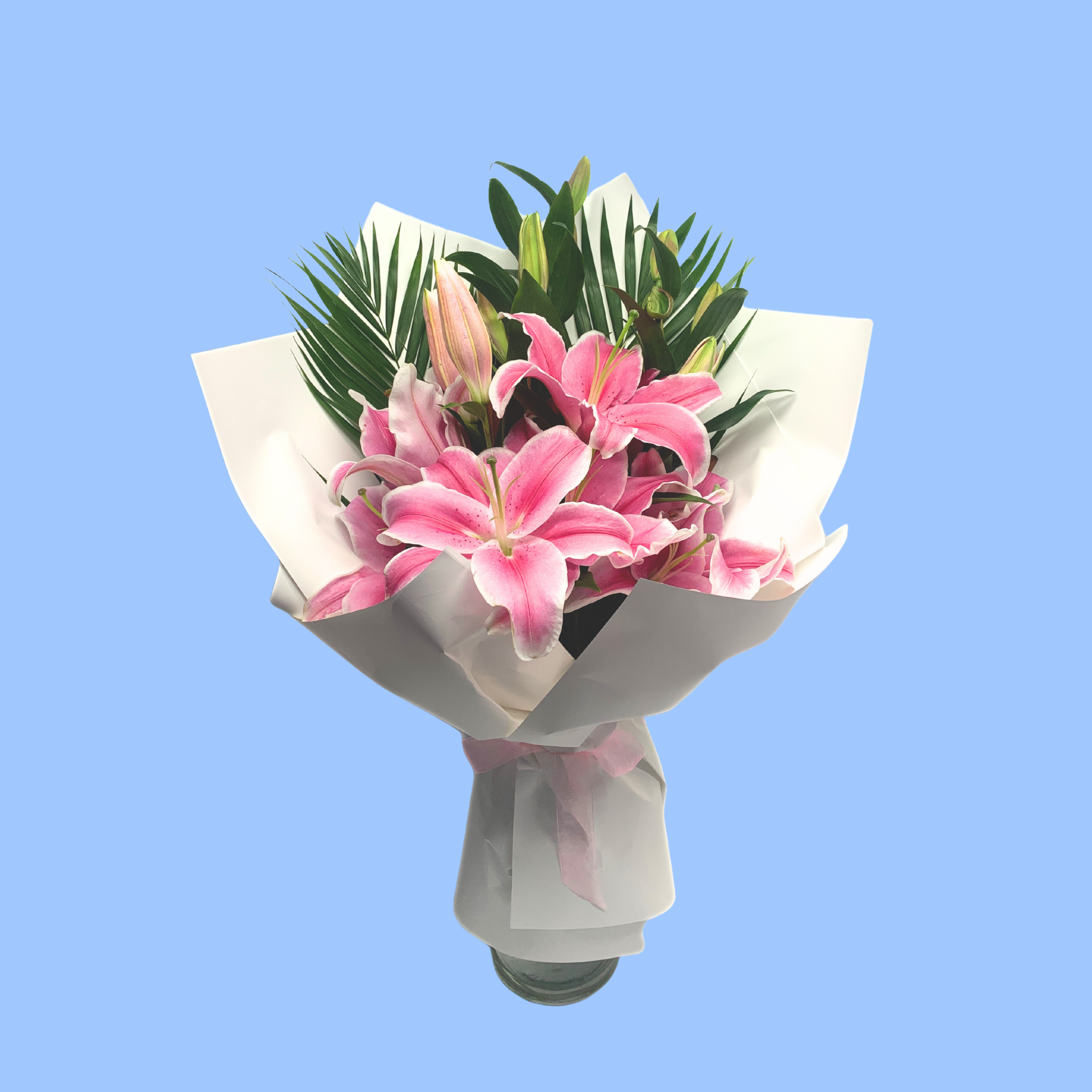Mixed white and pink lily bouquet in white wrap with light pink bow. shoes most lilies after they have opened