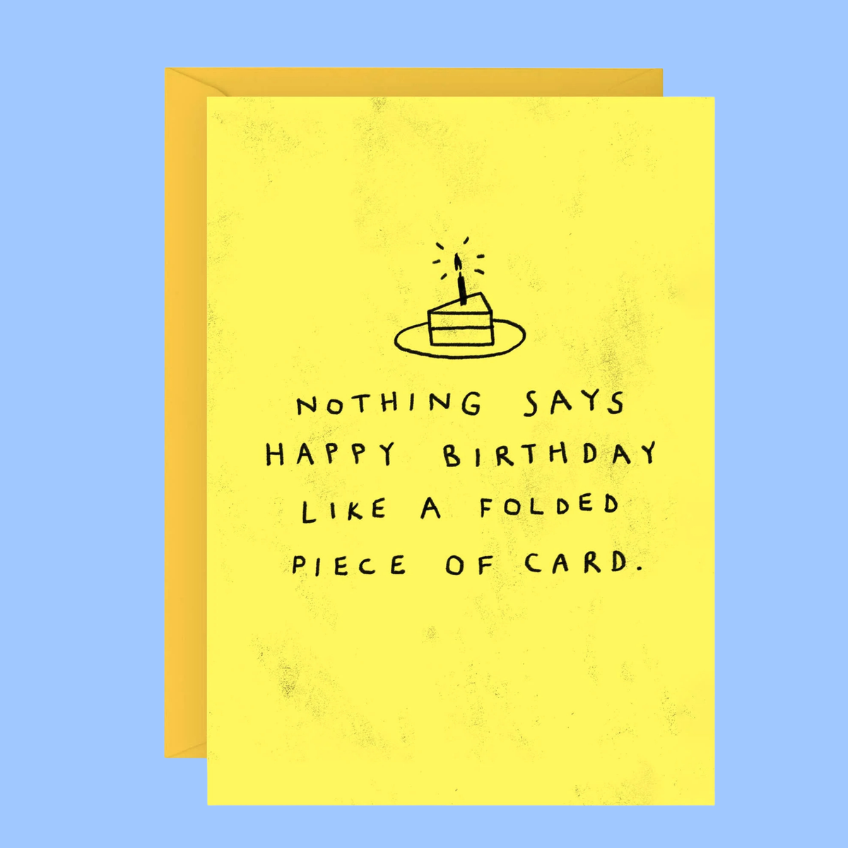 A folded yellow greeting card with a simple black line drawing of a birthday cake and the text 'NOTHING SAYS HAPPY BIRTHDAY LIKE A FOLDED PIECE OF CARD.' shown in front of a matching yellow envelope on a light blue background.
