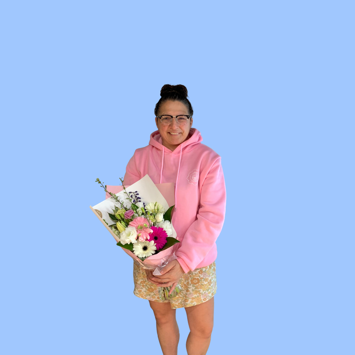 Laura King holding Pastels coloured flower bouquet wrapped in pink and white.