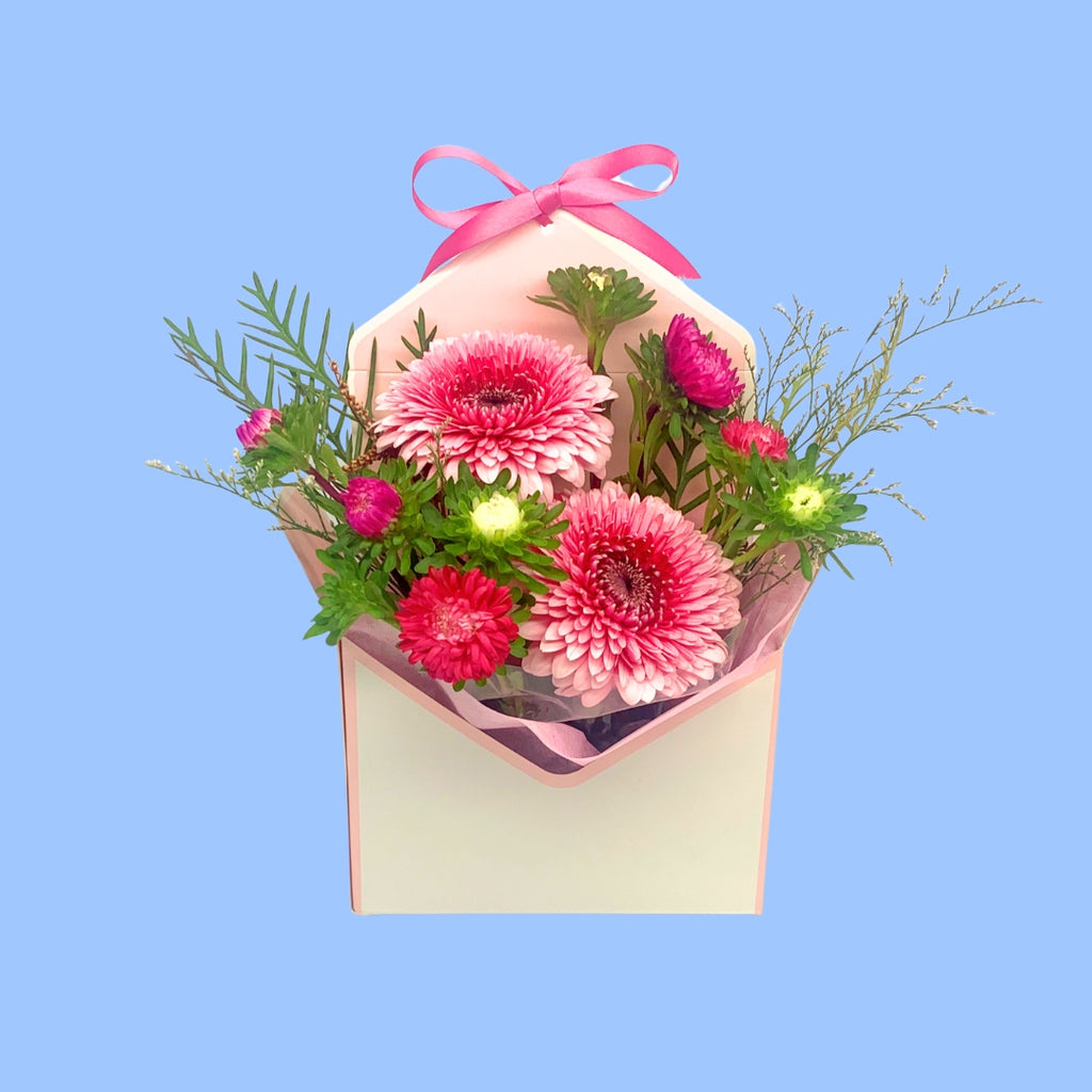 front view of Pink Floral arrangement in an envelope shaped box with pink vilene and a pink bow 