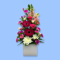 Tall upright arrangement of pink and white flowers in a white box