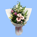soft pastels coloured flowers in a bouquet wrapped in white with light pink bow