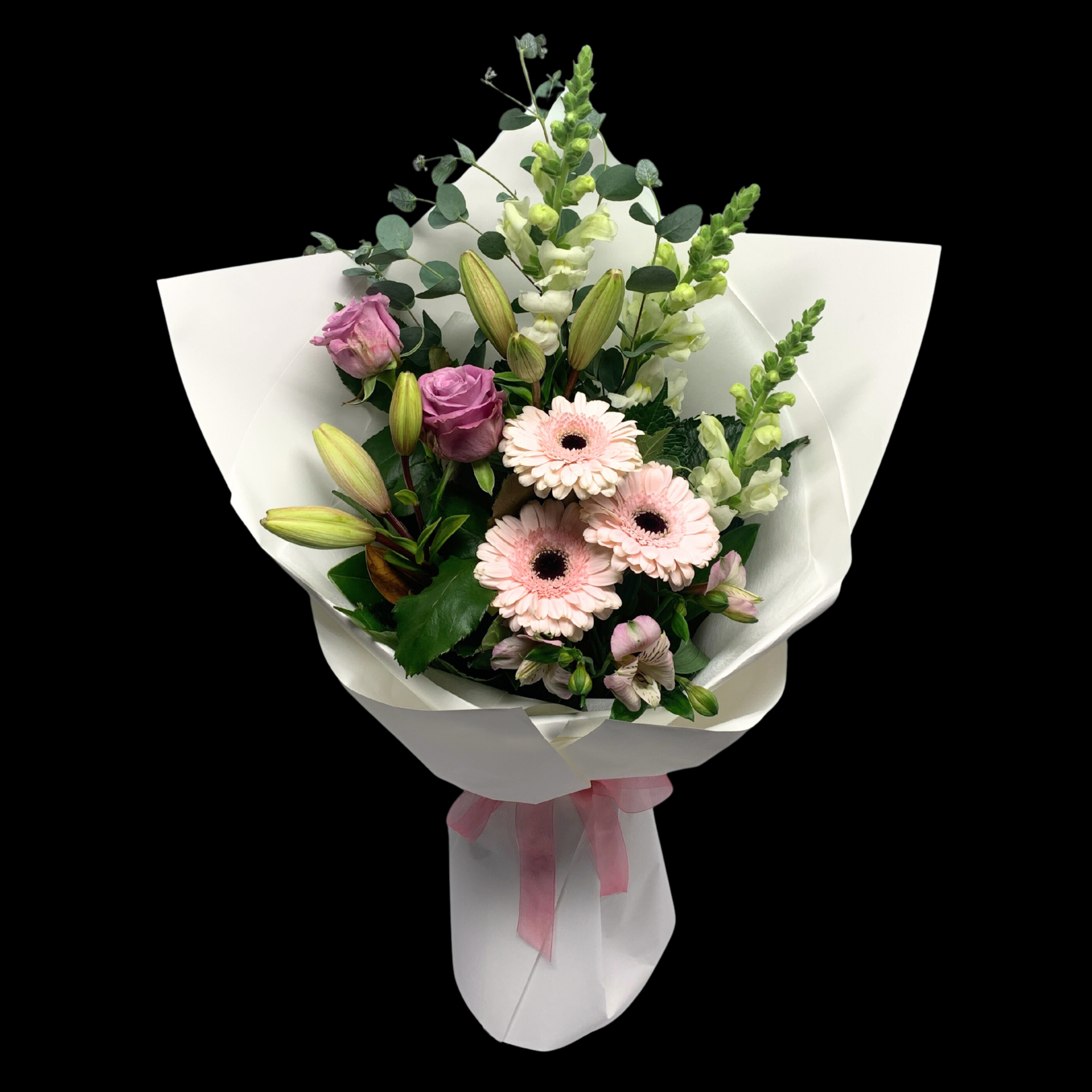 Soft Pastels coloured flowers in a bouquet wrapped in white with pink bow.