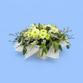 Arrangement of lime and white flowers in a white box line with white tissue
