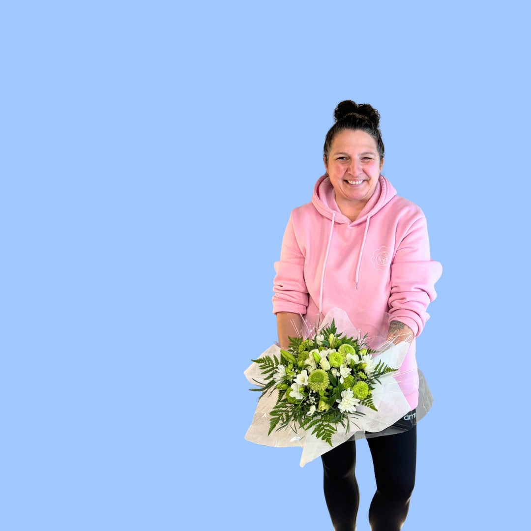 Laura King holding an Arrangement of lime and white flowers in a white box line with white tissue