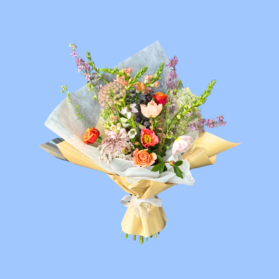 Natural wild-style bouquet with seasonal pastel flowers craft wrapped and white vilene.white bow