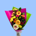 Bouquet of colorful flowers wrapped in pink paper and lime green.