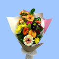 Bouquet of colourful flowers wrapped in kraft, pink and white.