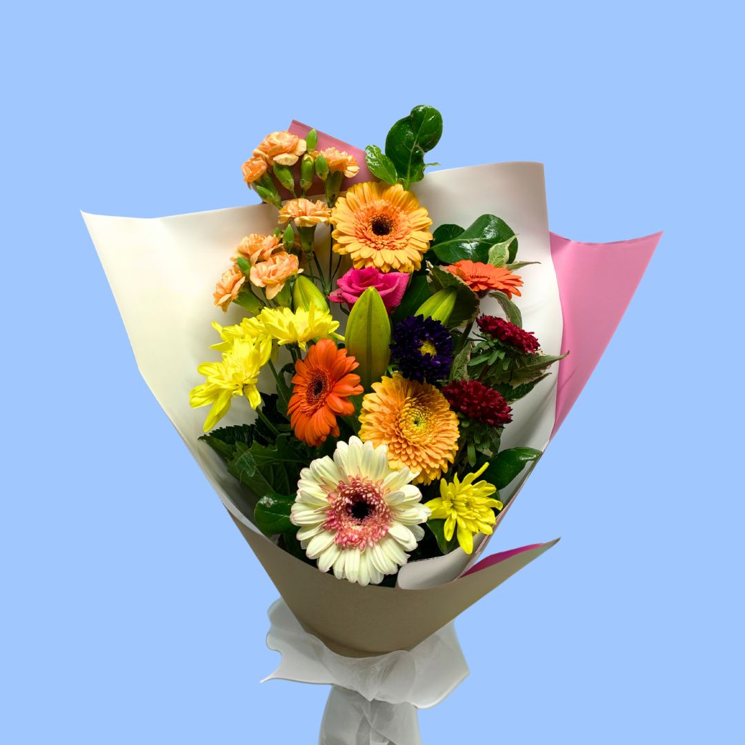 Bouquet of colourful flowers wrapped in kraft, pink and white.