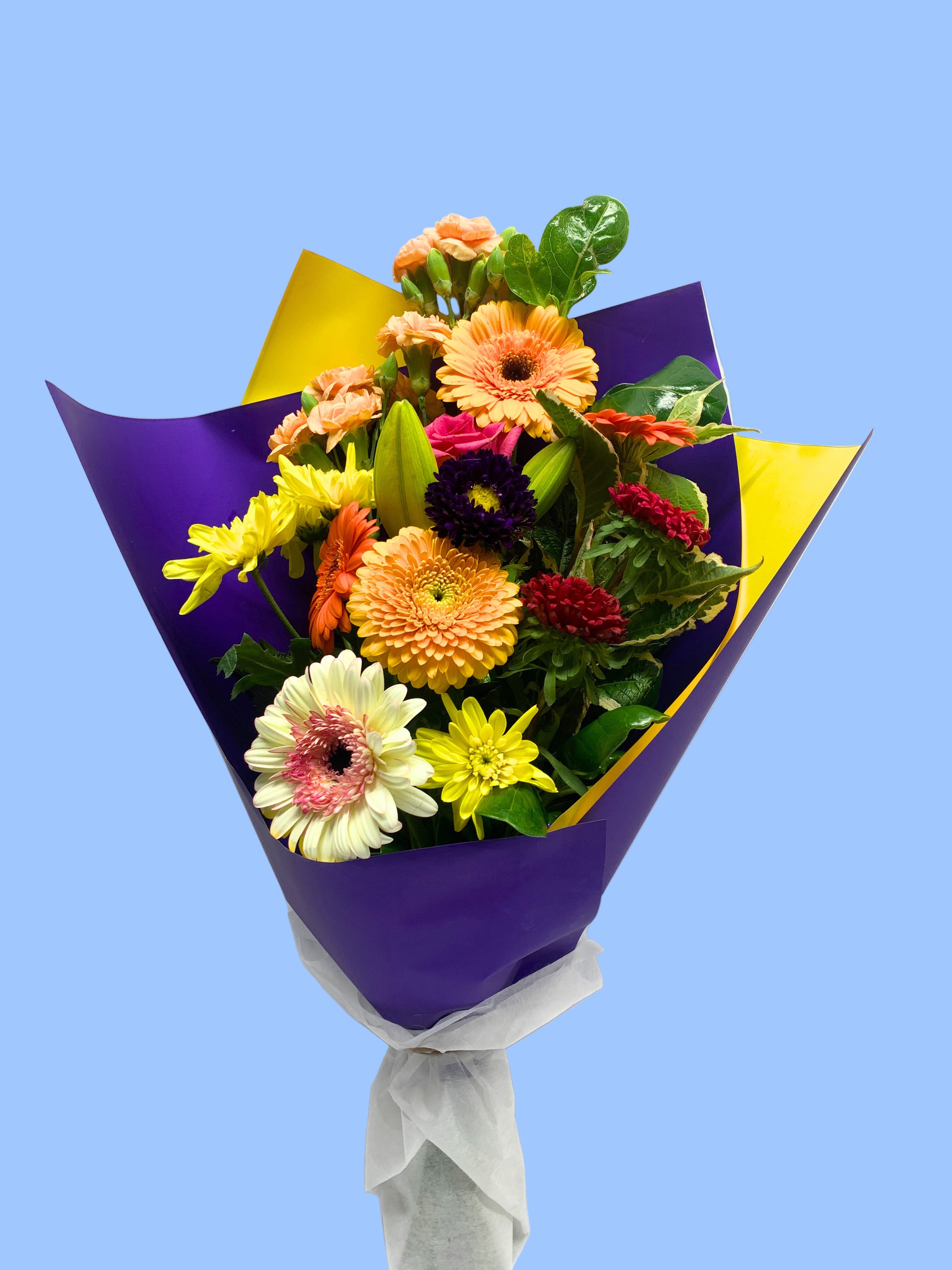 Bouquet of colourful flowers wrapped in purple and yellow.
